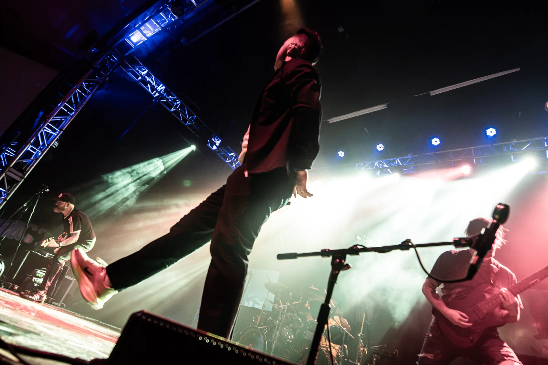Elite’s vocalist at the front of the stage under white lights