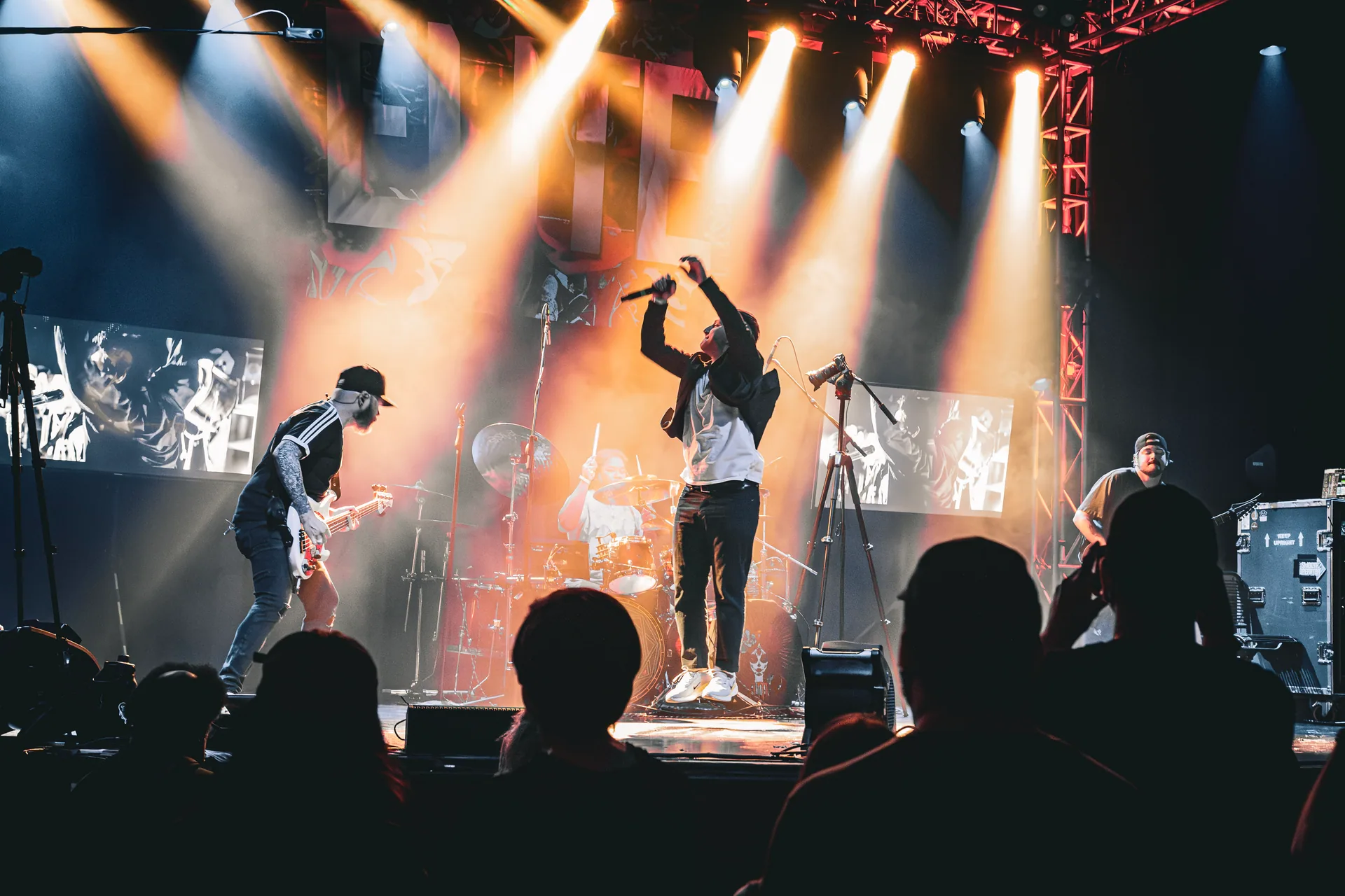 Elite on stage beneath white and amber lights at Granada Theatre