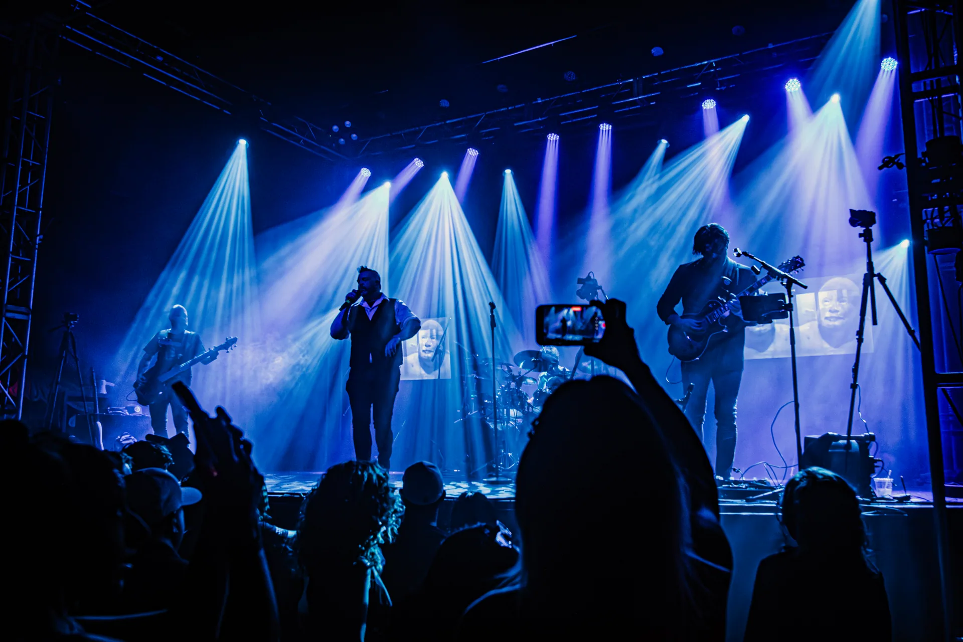 Jambi performing beneath blue and white beams at Granada Theatre